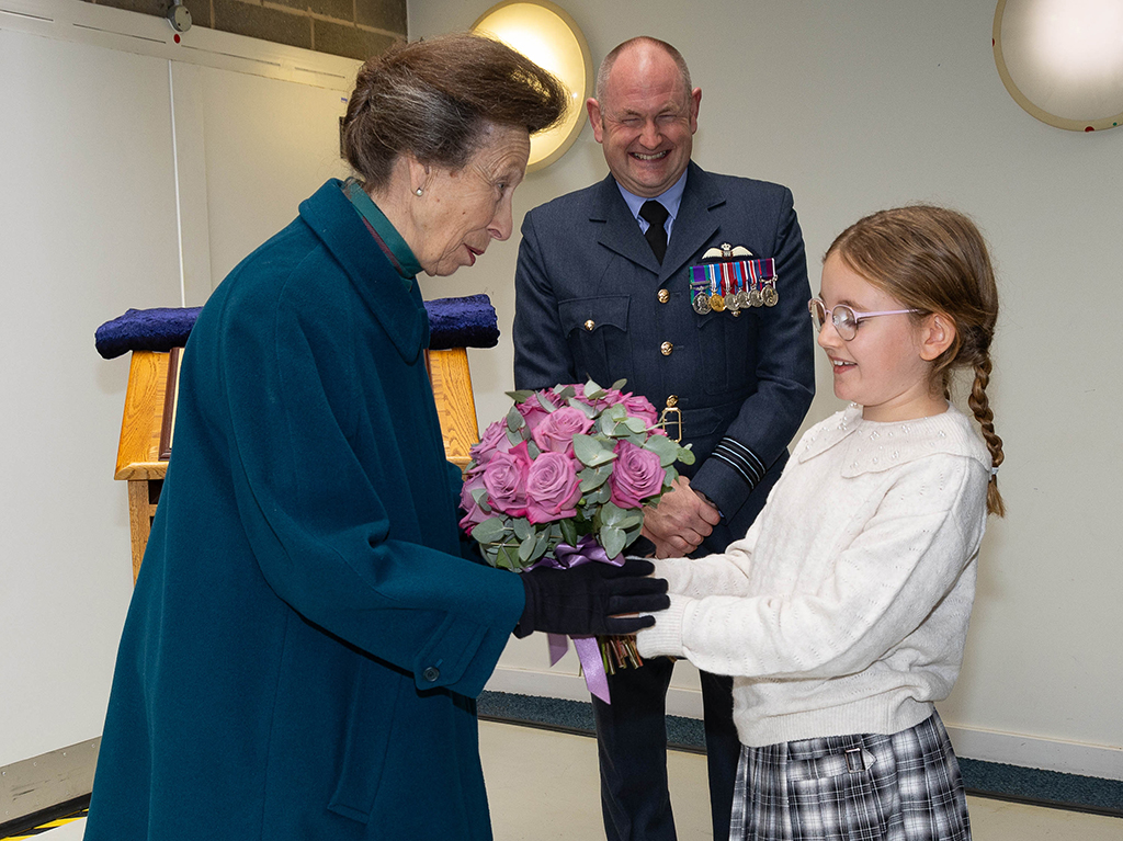 Her Royal Highness, The Princess Royal receives flowers, presented by Wing Commander Dow's daughter.